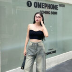 K-pop idols in wide-leg jeans set against an urban backdrop, embodying the trend.